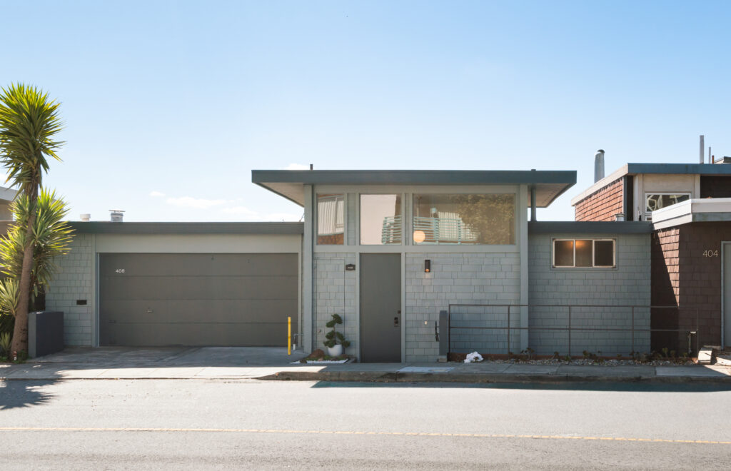Picture of front facade of mid-century home in gray, yucca tree to left at 408 Gold Mine Drive, San Francisco.