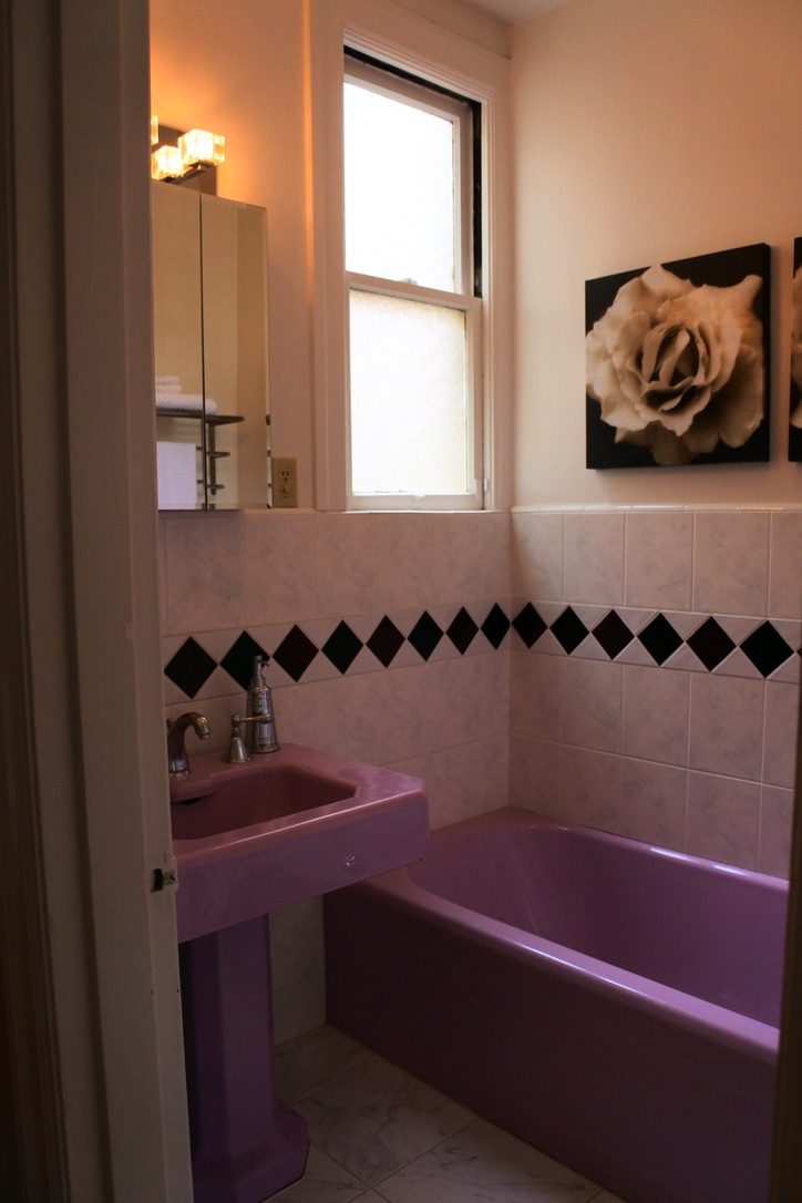 Vintage lavender bathroom with a black diamond tile border in a District 2 home.