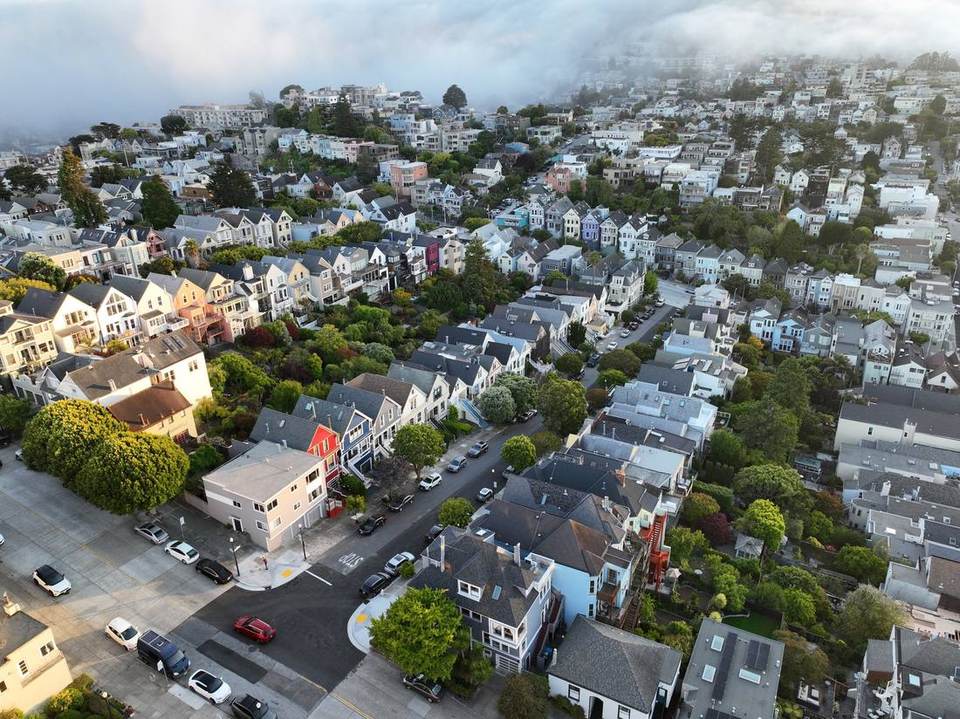 Aerial view of Victorian homes in Noe Valley with fog moving across the hills.
