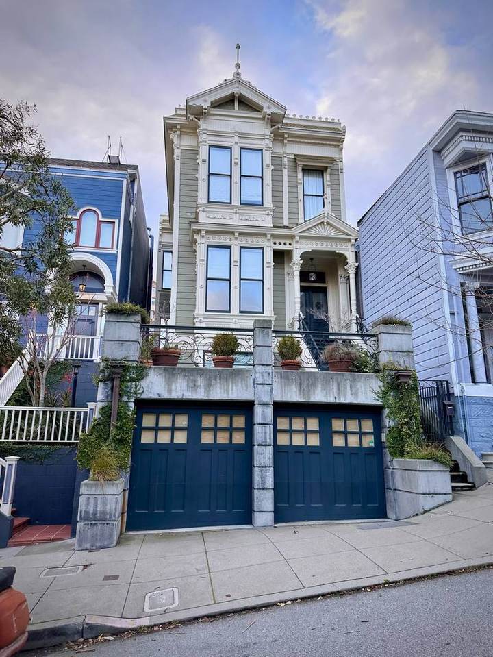 Victorian house with bay windows above a concrete garage