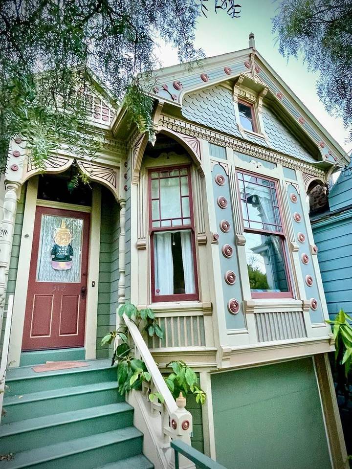 Victorian cottage with ornate bullseye rosettes and decorative shingles