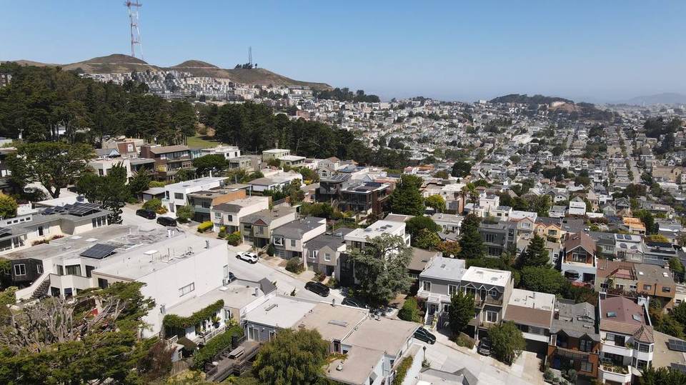 Aerial view of hillside houses and view decks with Twin Peaks behind