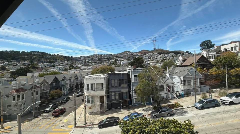 View from an upper window across a San Francisco street corner toward Sutro Tower